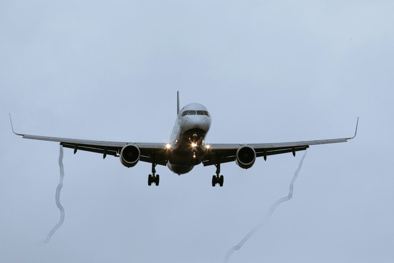 a large jetliner flying through a cloudy sky